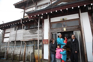 引っ越してきた空き家の前に立つ北野さんと表区長