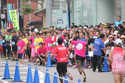 大勢の参加者がランナーを見守るリレーゾーン.jpg